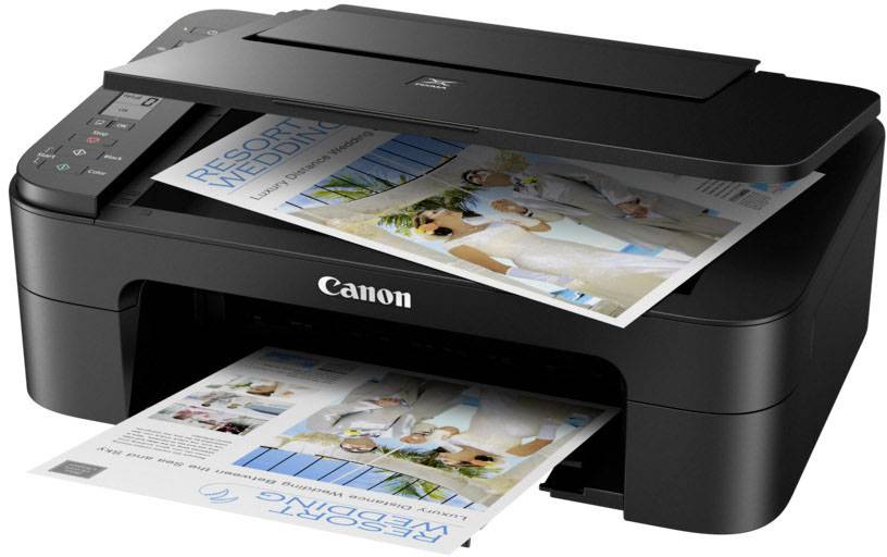 Een zwarte Canon-printer drukt een kleurrijke foto van mensen af. De printer staat op een wit oppervlak.