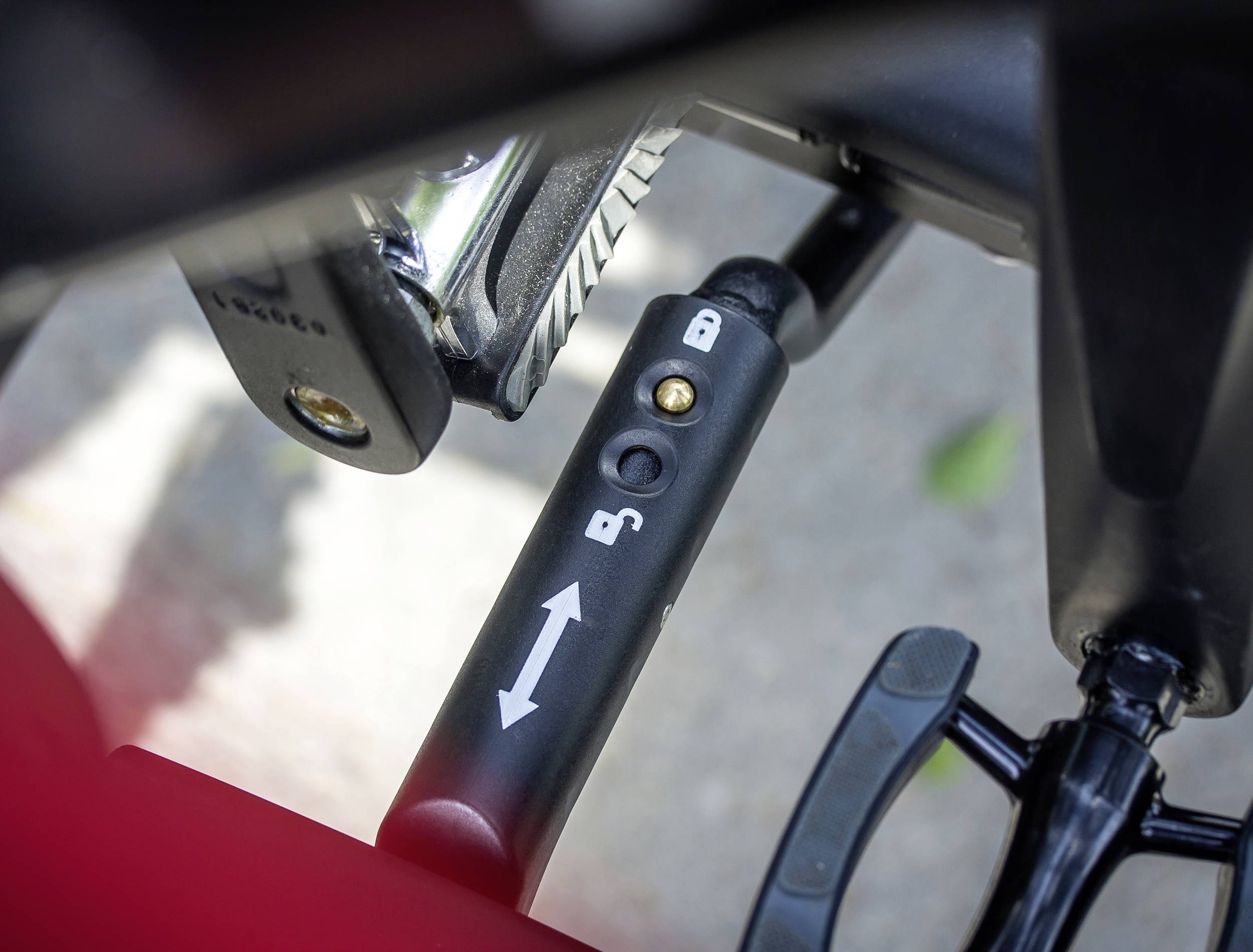 Fietsslot met pijlen en symbolen voor open en gesloten. Voornamelijk zwart met een klein kijkvenster aan de buitenkant.