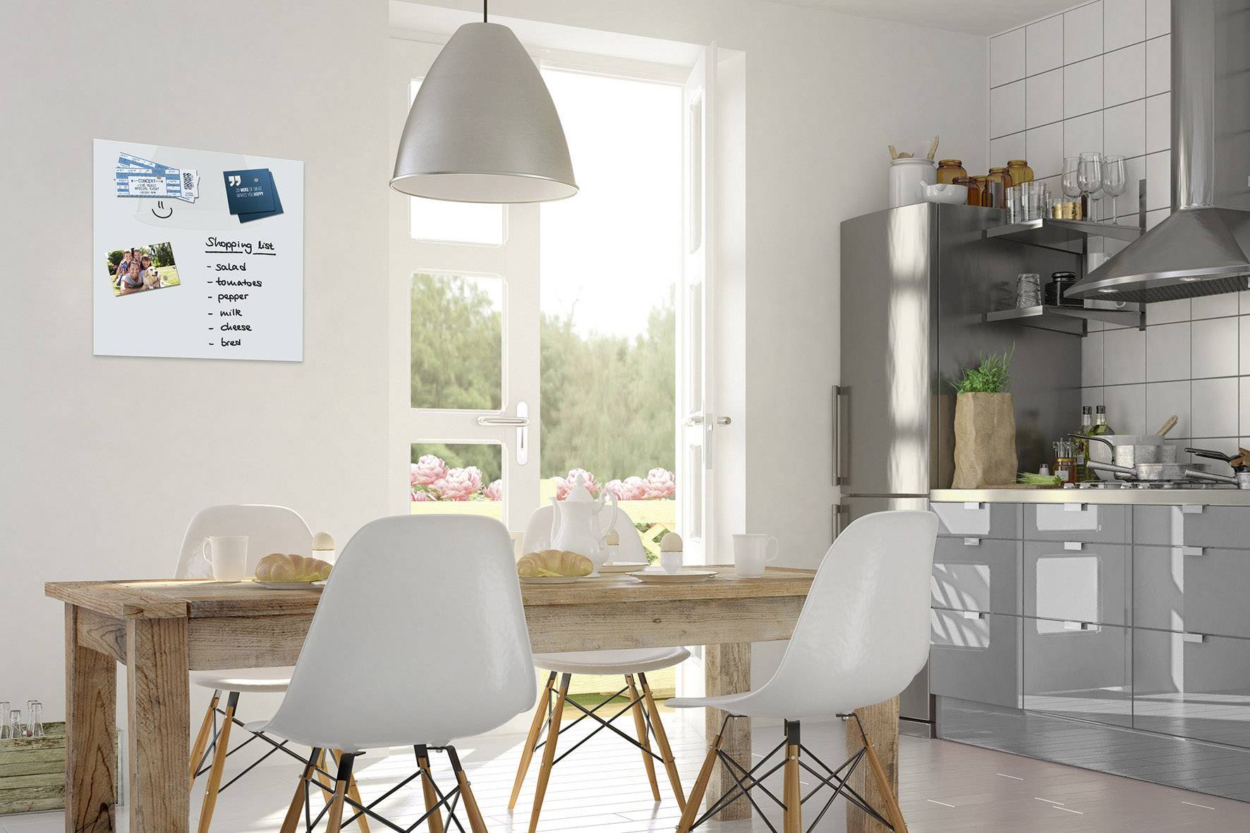 Een moderne keukenruimte met een houten tafel, witte stoelen en een boodschappenlijstje op een whiteboard aan de muur. Lichte, ruimtelijke sfeer.