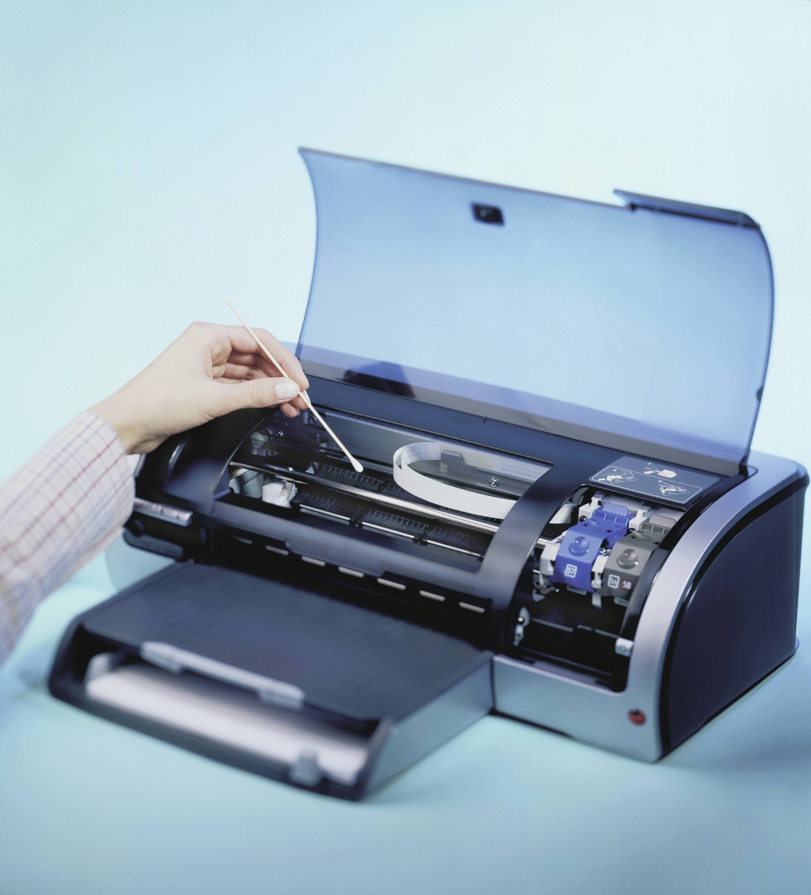 Een hand bedient een computerprinter via de bovenste lade. De printer staat voor een lichtblauwe achtergrond.