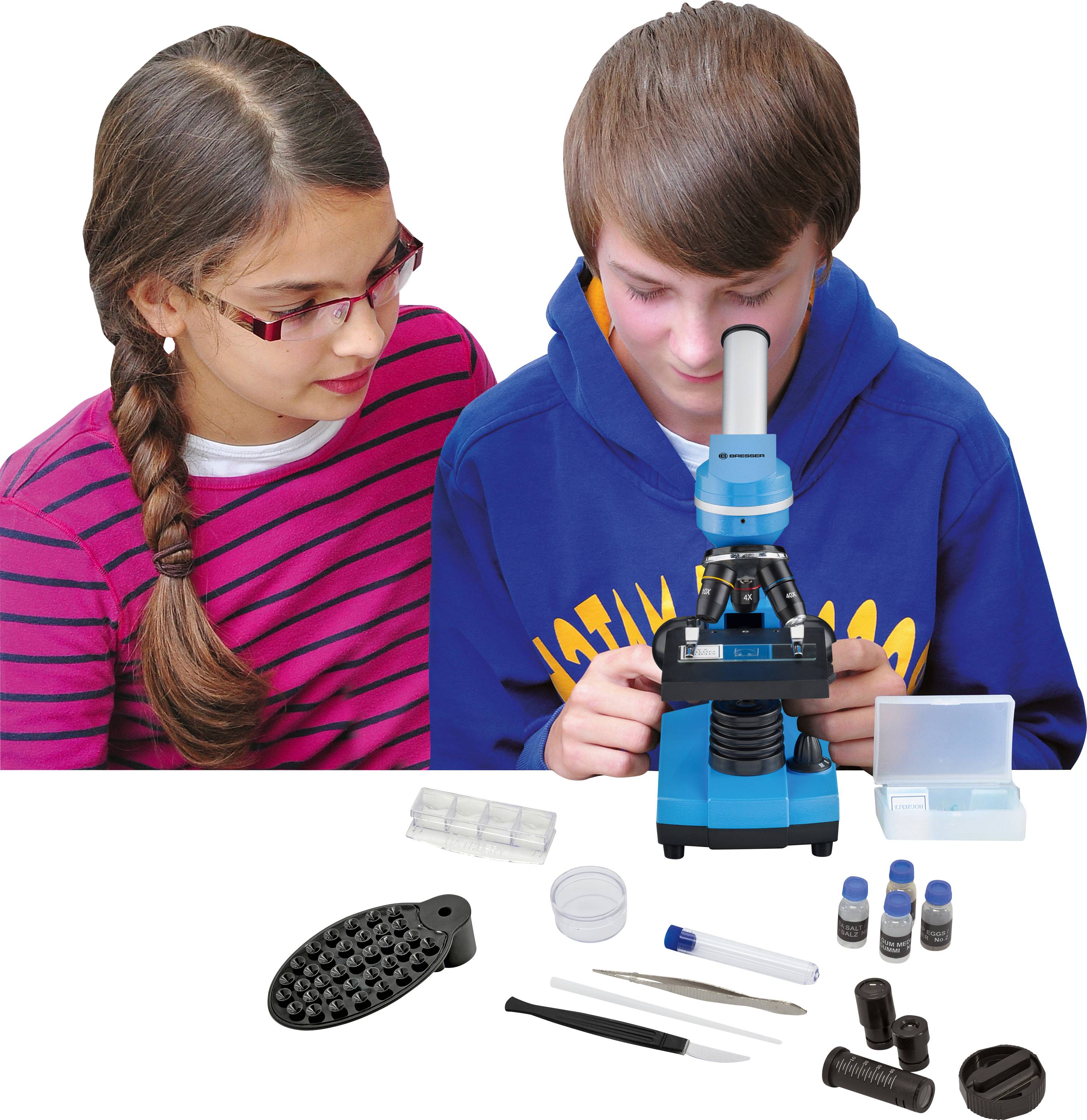 Twee kinderen bestuderen een microscoop. Ze lijken geïnteresseerd en zijn omringd door microscoopaccessoires, zoals objectglasjes en flesjes.