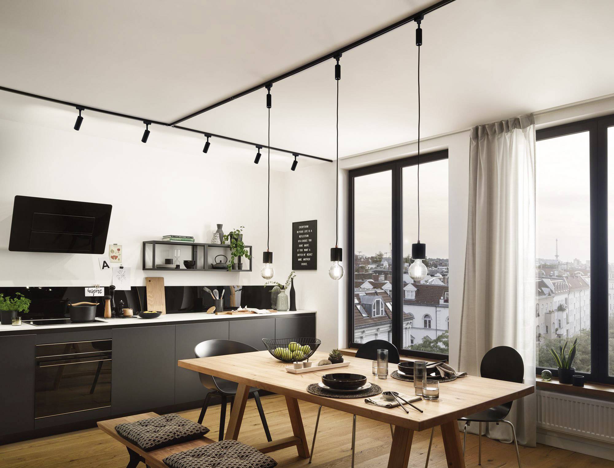 Moderne keuken met eettafel, hangende lampen en grote ramen met uitzicht op de stad. Lichte en uitnodigende sfeer.