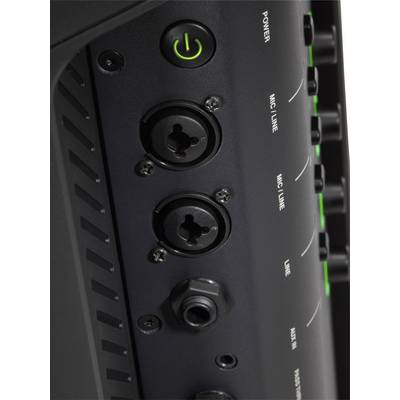 Close-up van een zwarte audio-versterker met meerdere aansluitingen en een groen verlichte aan-knop.