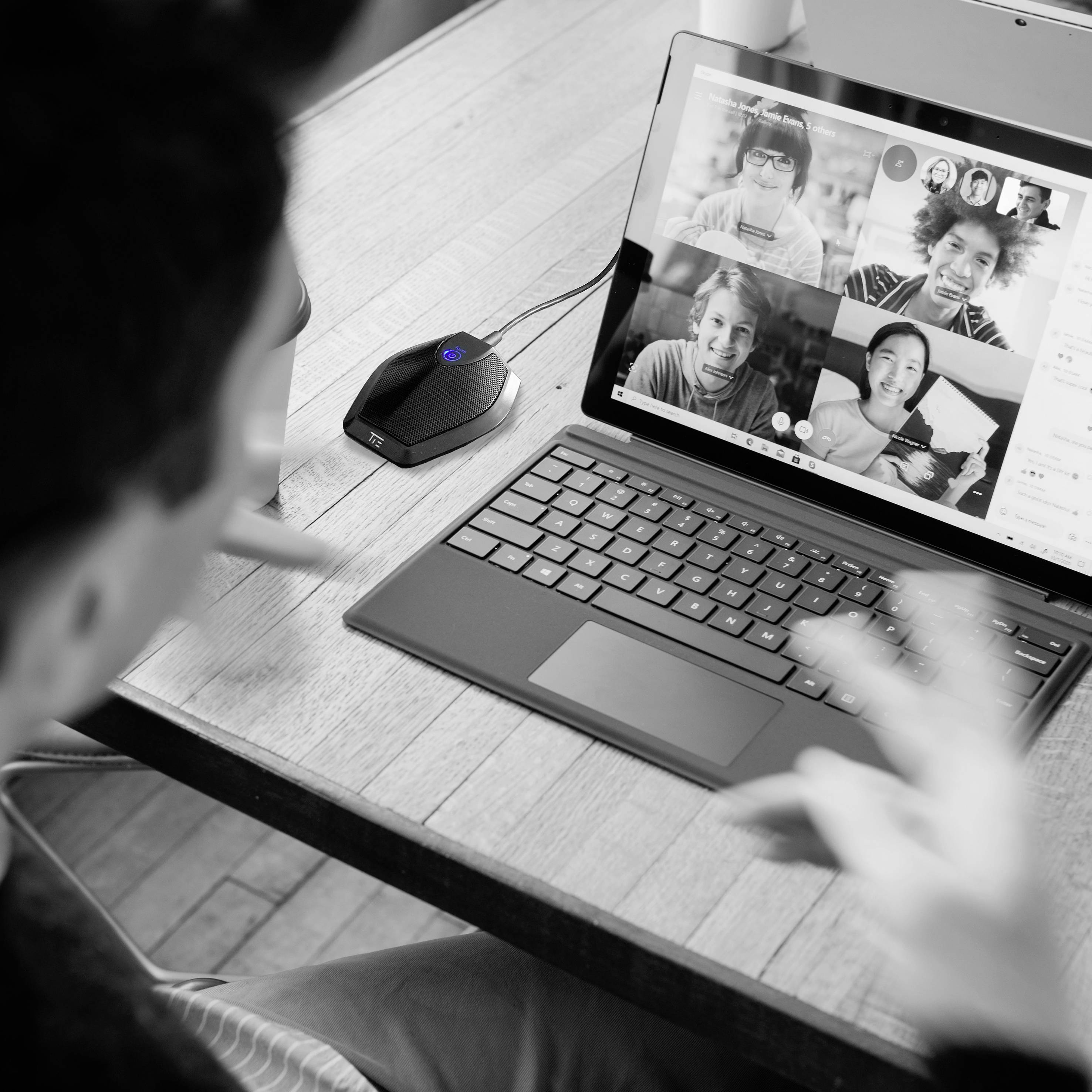 Een persoon neemt deel aan een videoconferentie met meerdere deelnemers die zichtbaar zijn op het laptopscherm.