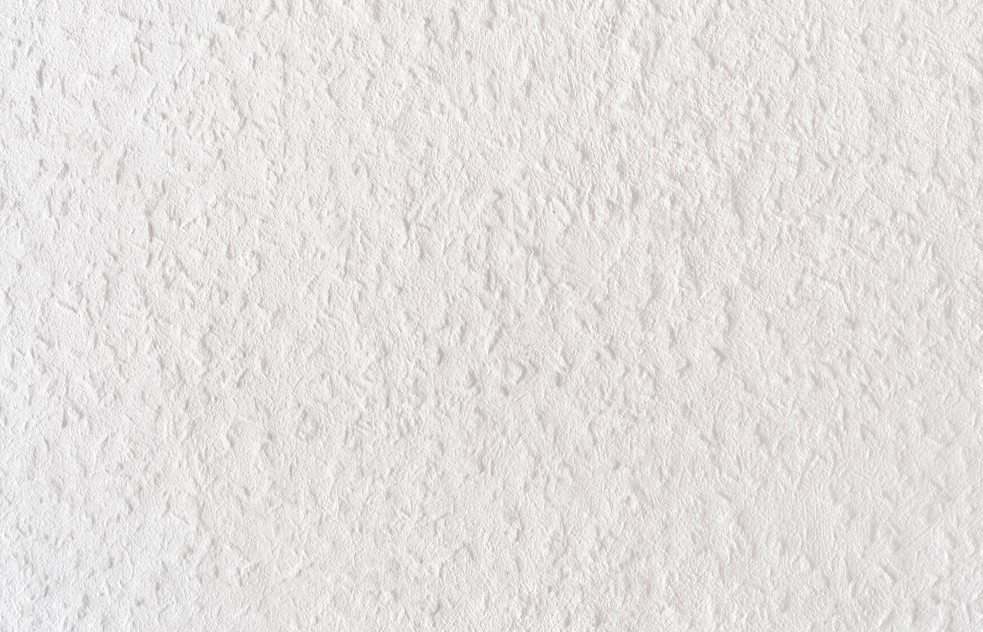 Close-up van een witte gestructureerde muur of papiervlak met subtiel reliëfpatroon en schaduwen.
