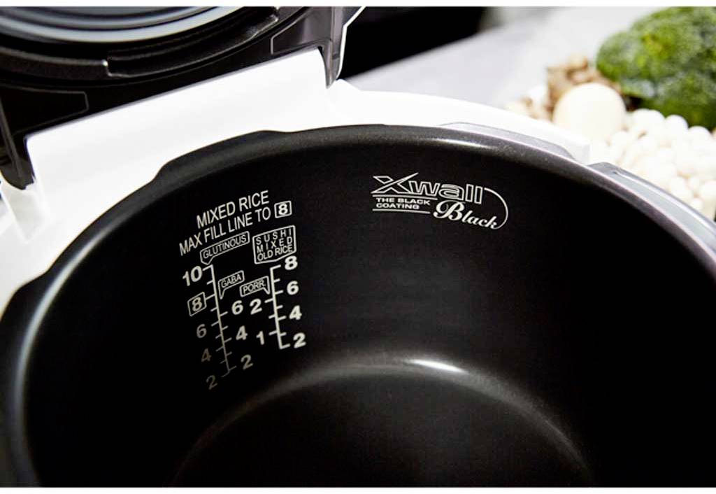 Binnenaanzicht van een rijstkoker met zwarte coating, een waterstandsindicator en de tekst 'Xwall Black' aan de binnenkant.
