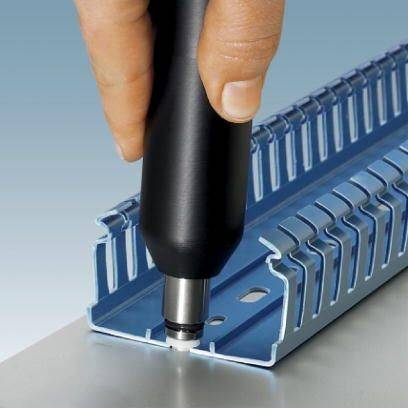 Een hand houdt een zwart apparaat boven een blauwe kabelgoot, waarbij het gereedschap de goot lijkt te markeren of te bewerken.