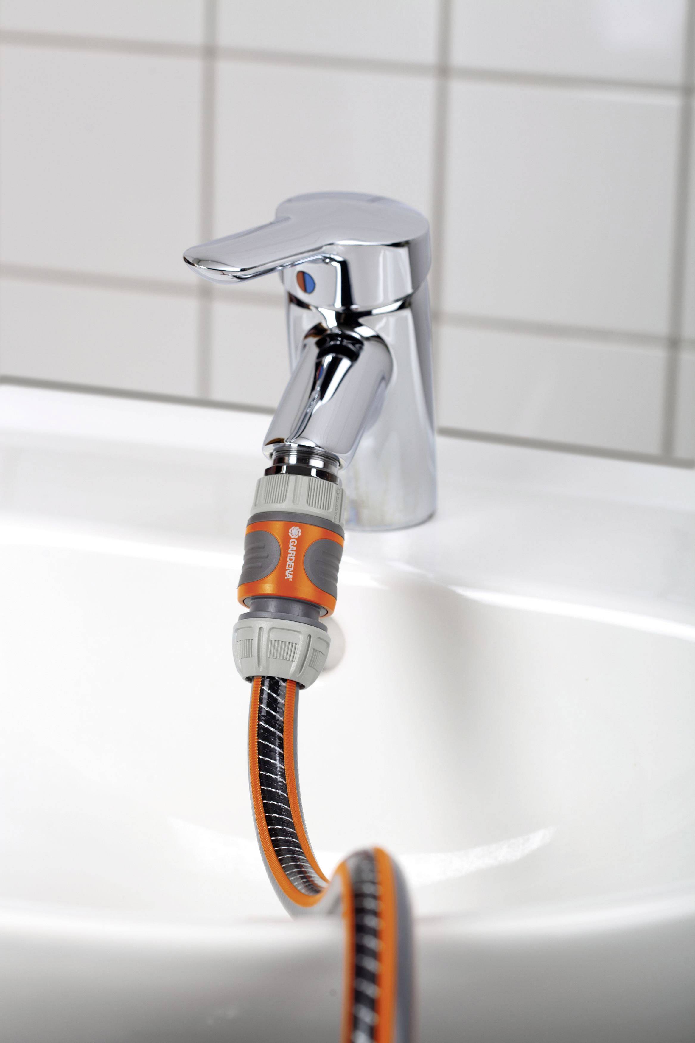 Een waterkraan met een aangesloten tuinslangadapter toont een efficiënte manier om een tuinslang met de binnenkant te verbinden.
