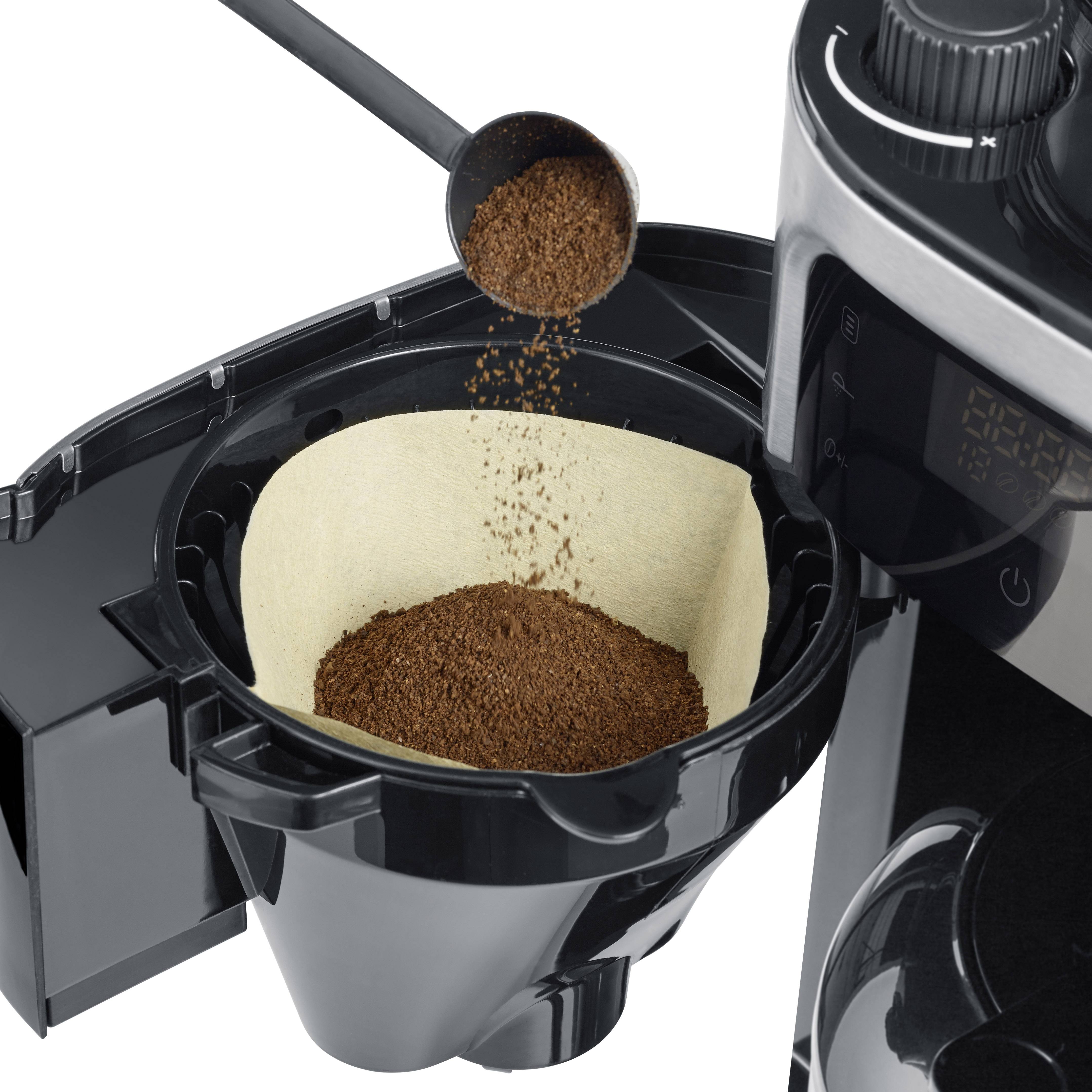 Koffiezetapparaat met open filtervak. Een lepel doet koffiemolen in het filter.
