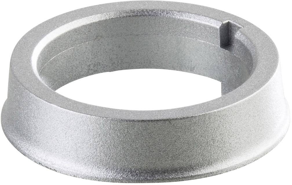 Een zilveren, ronde metalen ring met een klein lipje aan de zijkant, mogelijk een onderdeel voor een mechanische of industriële toepassing.