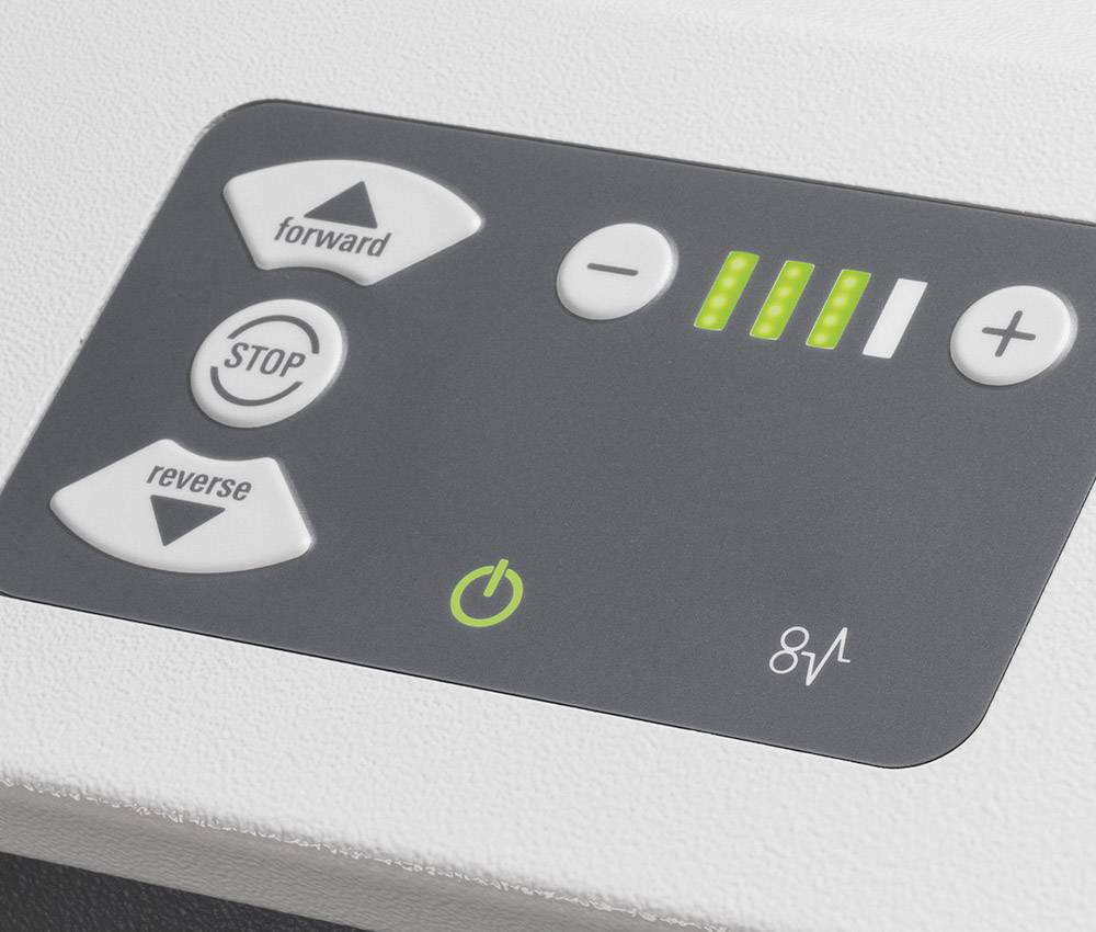 Bedieningspaneel van een technisch apparaat met knoppen voor 'Vooruit', 'Stop' en 'Achteruit', evenals een display met groen oplichtende balken.