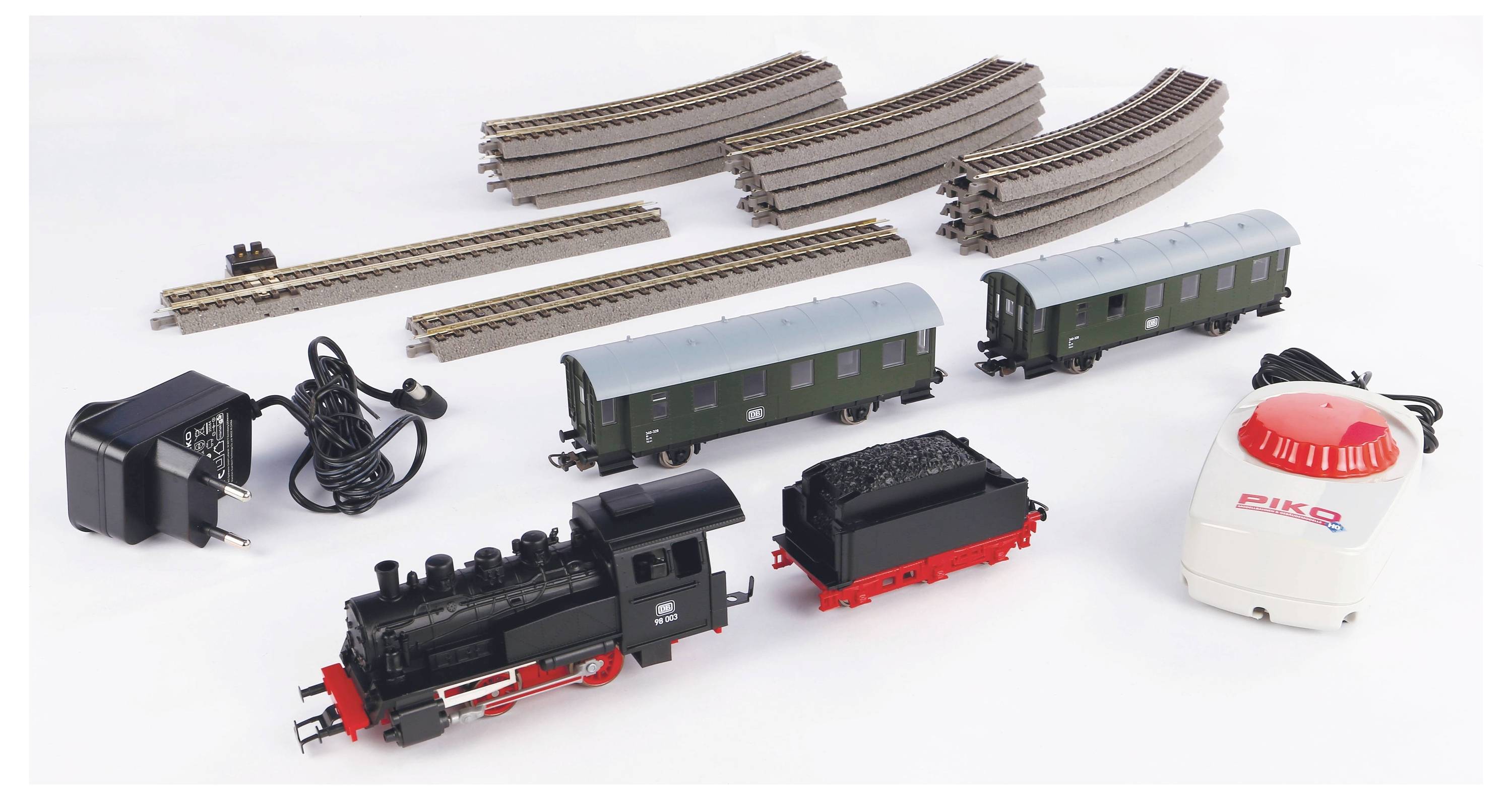 Modelspoorbaan-set met rails, twee wagons, locomotief, besturingsapparaat en voedingsadapter. Rails in bochtige en rechte vorm.