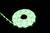 Een opgerolde groene LED-lichtsnoer schittert op een zwarte achtergrond.