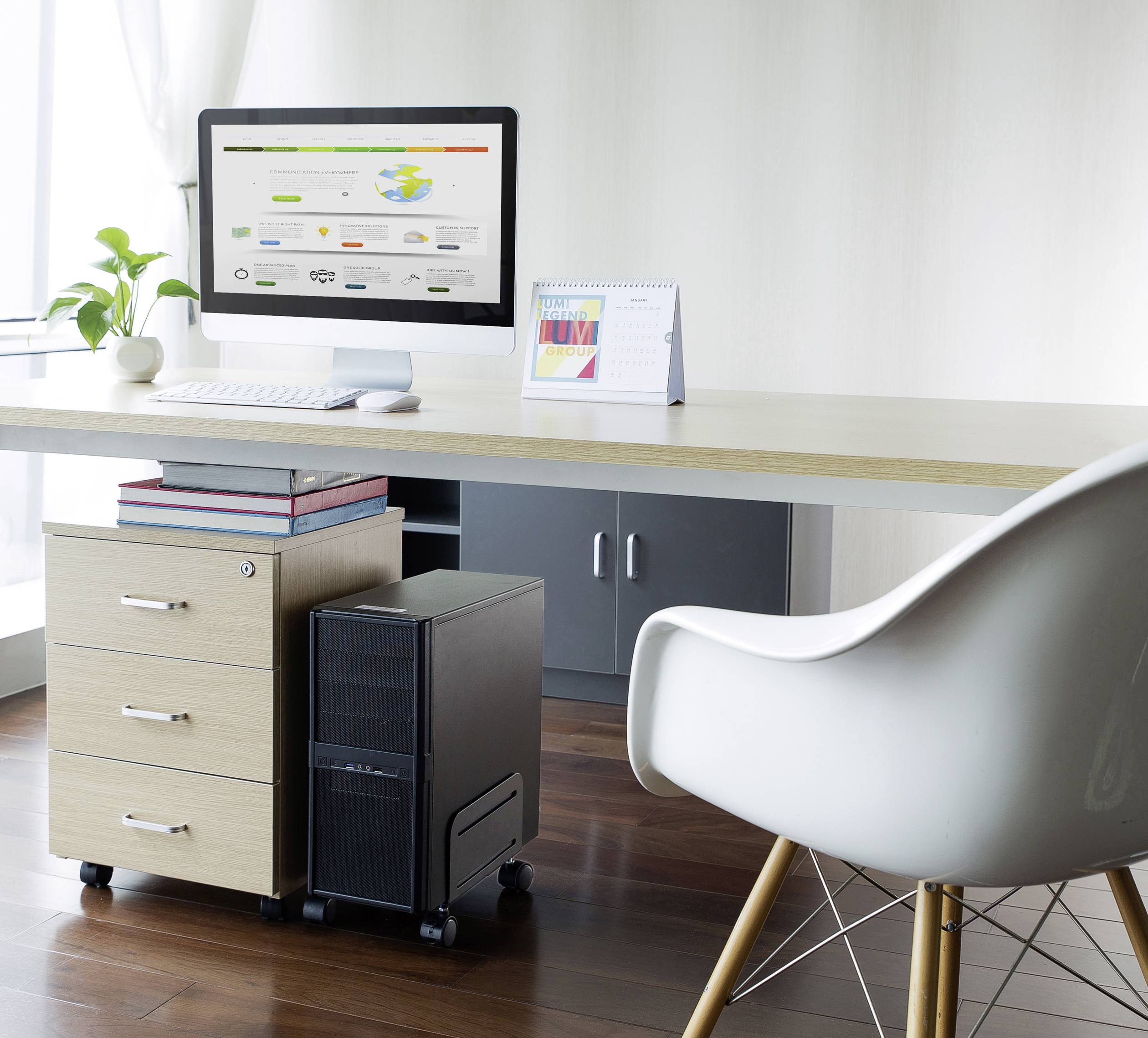 Moderne werkplek met computer op een bureau, bureaustoel, plant en kalender. Lichte, minimalistische inrichting.