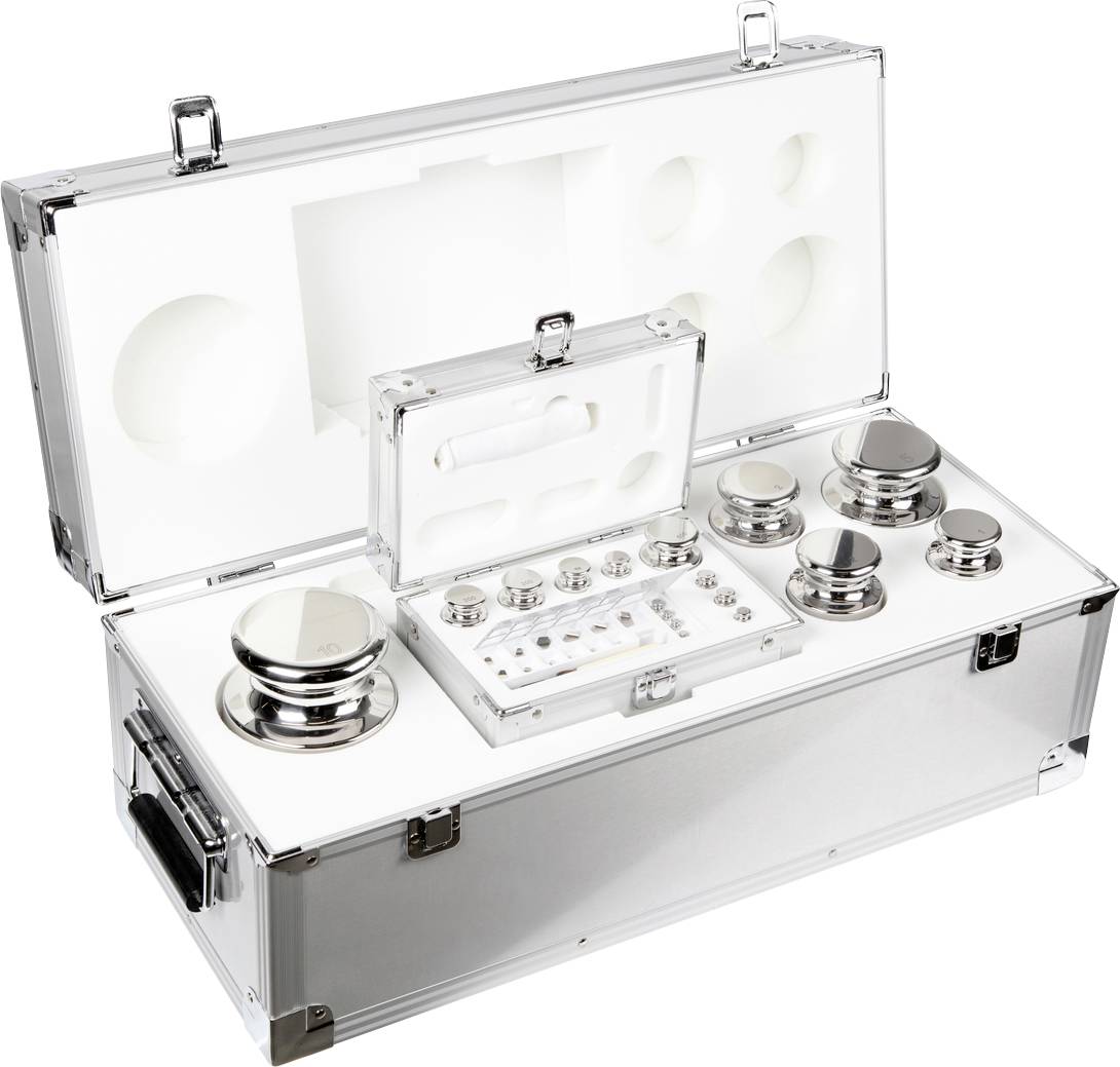 Metalen gewichten van verschillende afmetingen in een open aluminium koffer, gebruikt voor de kalibratie van meetapparatuur in laboratoria.