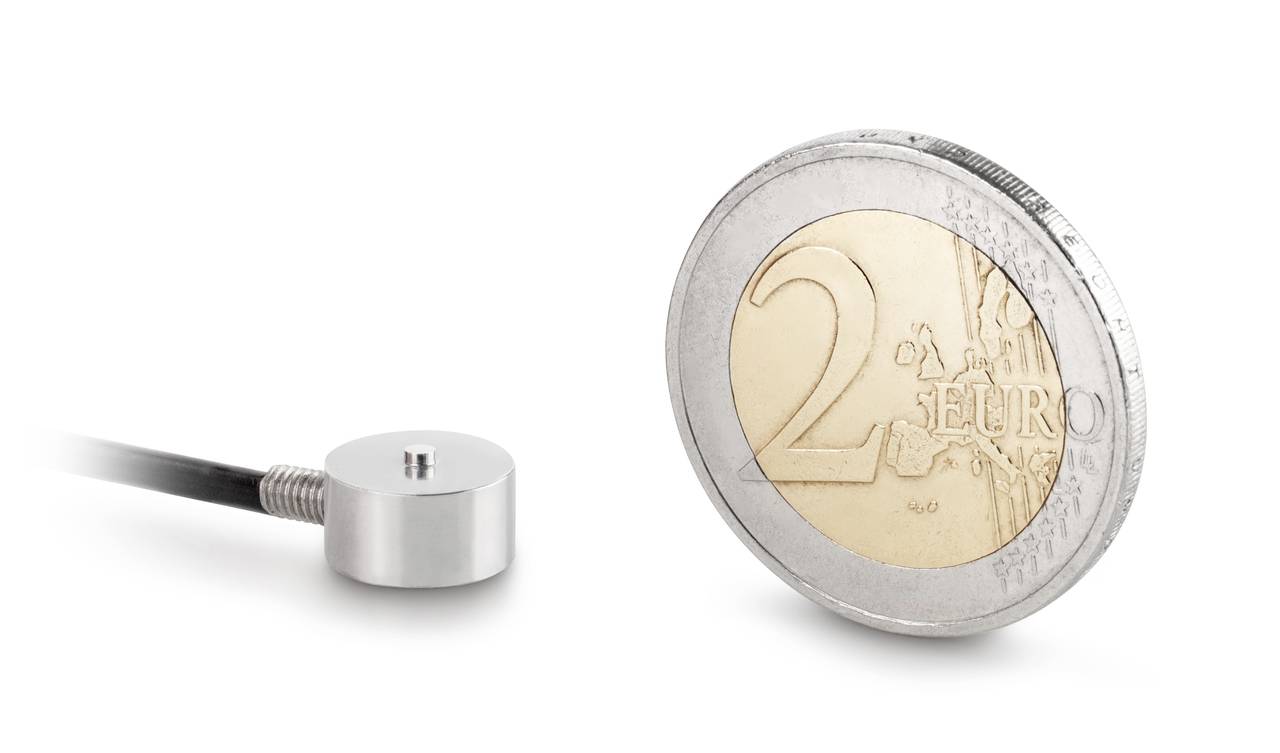 Een kleine, ronde sensor ligt naast een 2-euro-munt ter illustratie van de grootte van de sensor in vergelijking met de munt.