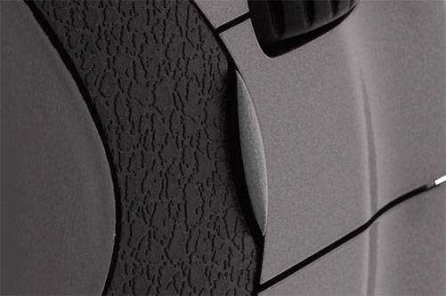 Close-up van een gestructureerd, grijs oppervlaktemateriaal met een smalle verticale lijn, waarschijnlijk onderdeel van een technisch apparaat.