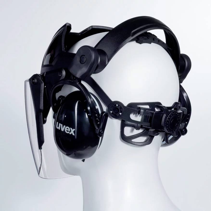 Veiligheidshelm met geïntegreerde gelaatsbescherming en gehoorbescherming. De helm is zwart en heeft een verstelbare hoofdband.