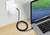 Een laptop is via een lang USB-kabel aangesloten op een stopcontact om de batterij op te laden.