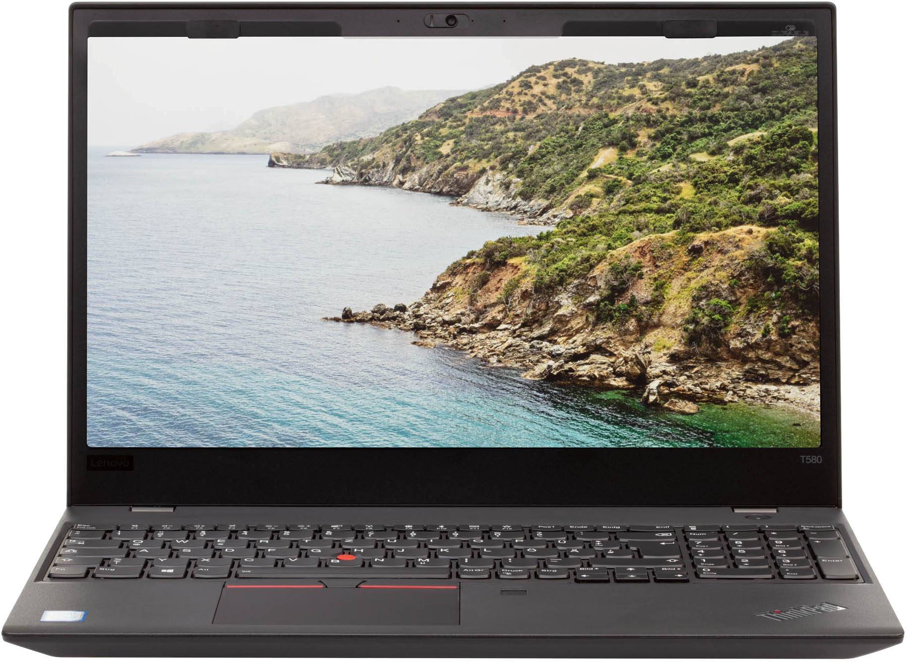 Een geopende laptop met een scherm waarop een kustlandschap wordt getoond. De laptop heeft een zwart toetsenbord en een trackpad.