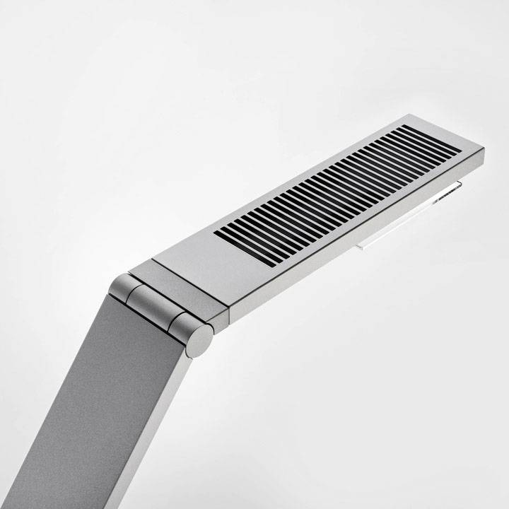 Een moderne tafellamp met een slanke, minimalistische ontwerp van metaal, voorzien van een rechthoekige lampenkop en een gewrichtsboom.