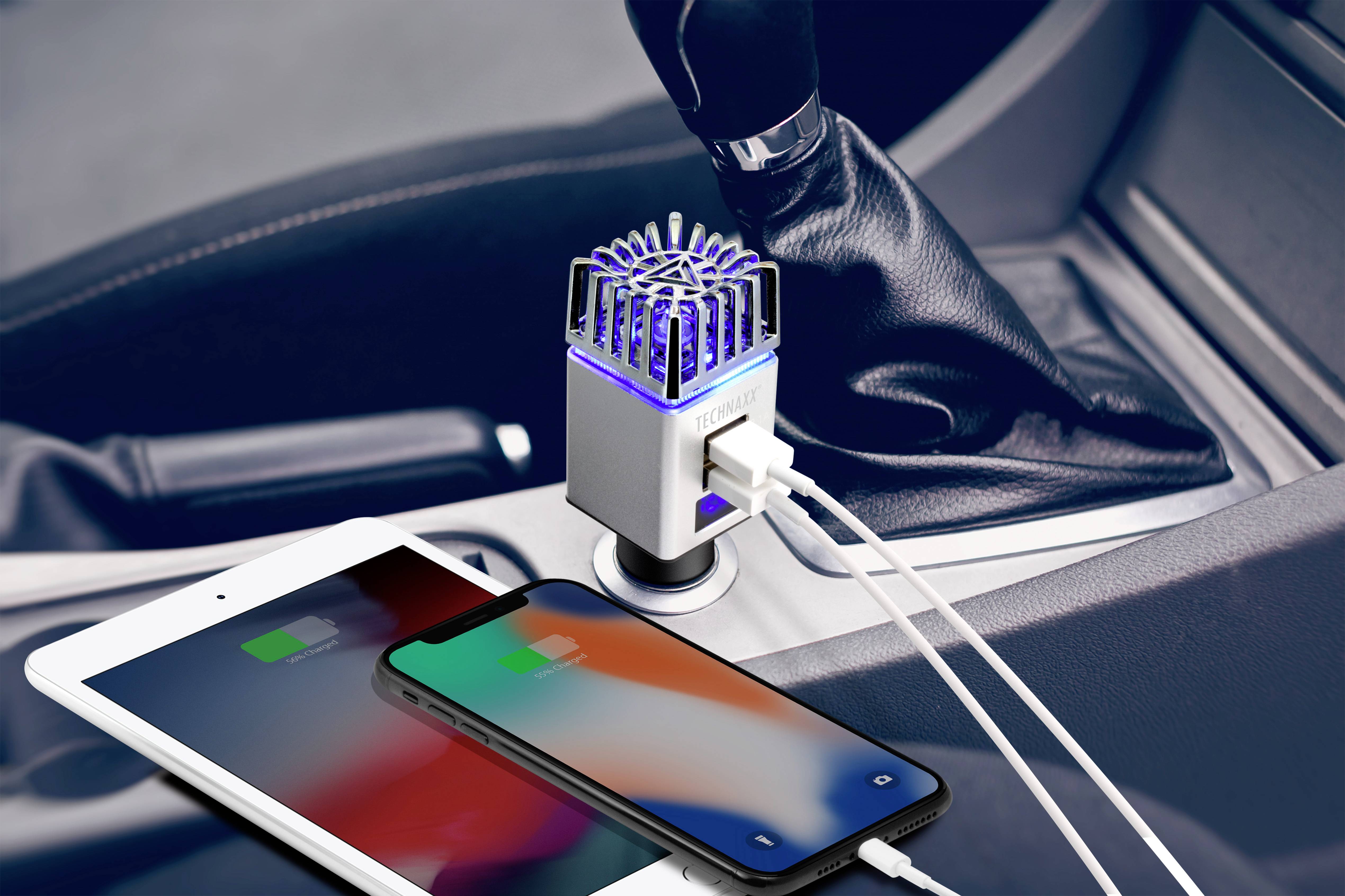 Het interieur van een auto met een oplader in de sigarettenaansteker. Twee apparaten, een smartphone en een tablet, worden succesvol opgeladen.