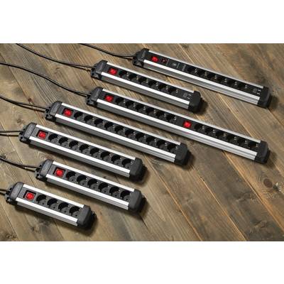 Zeven stekkerdozen van verschillende formaten liggen op een houten vloer. Elke stekkerdoos heeft een aan-/uitschakelaar en meerdere stopcontacten.