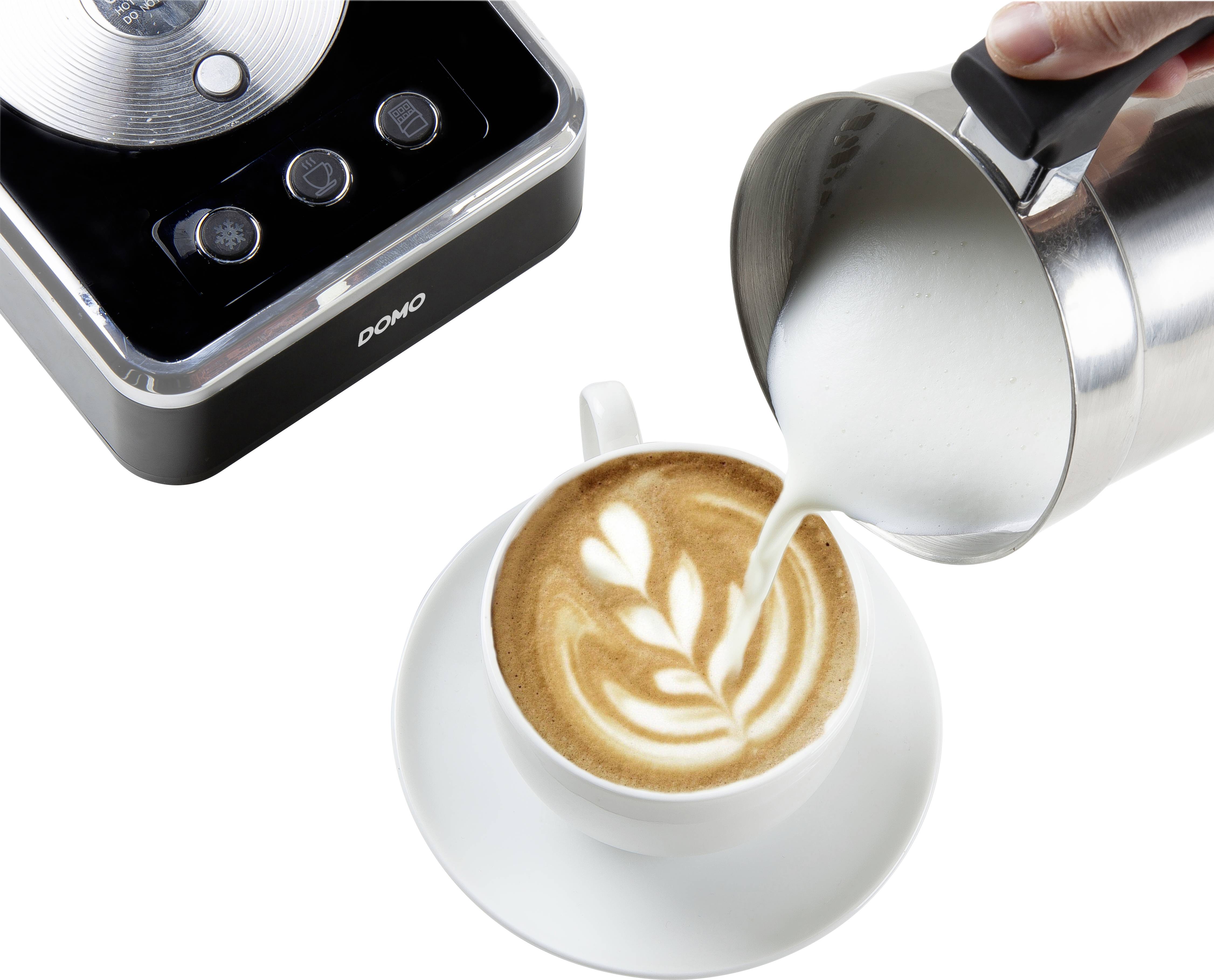 Een kopje cappuccino met latte art wordt aangevuld met opgeschuimde melk uit een roestvrijstalen kan. Links is een elektrische melkopschuimer te zien.