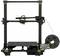 Een 3D-printer met een zwart frame en een filamentrol aan de zijkant, klaar om te printen.