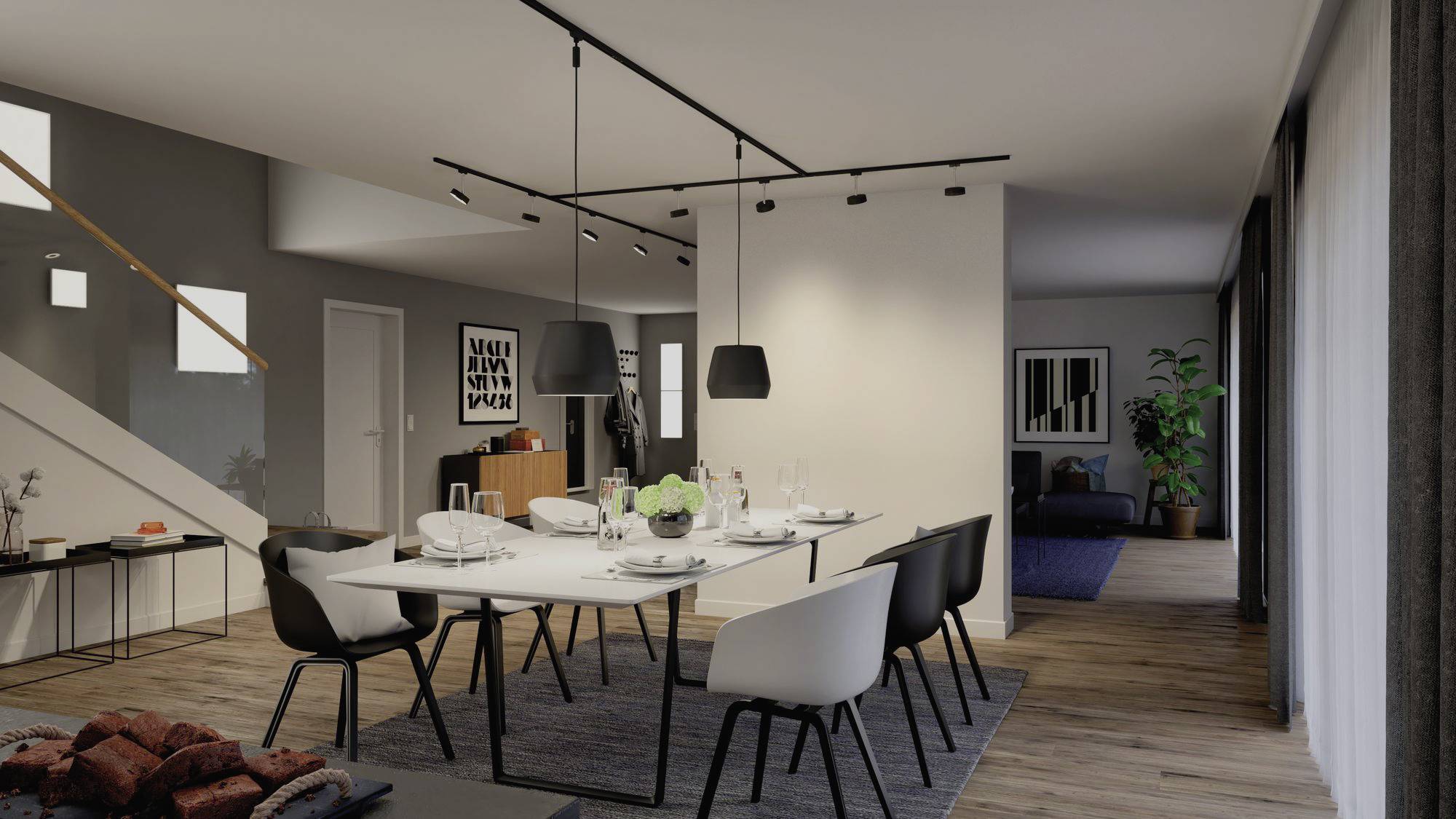 Eetkamer in modern huis, grote tafel met wit tafelkleed, zwarte stoelen, stijlvolle hangende lampen, trap op de achtergrond.