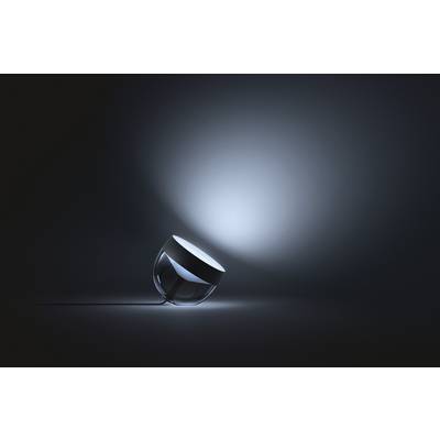 Een moderne glazen bol-lamp die schuin ligt en zacht licht uitstraalt in een donkere ruimte. De verlichting creëert een rustgevende sfeer.