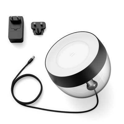 Ronde, transparante luidspreker met zwarte rand, kabel en twee stopcontactadapters.