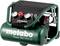 Een draagbare groene compressor met twee drukindicatoren en rode ventielen, gemarkeerd met 'metabo Power 250-10 W OF'.