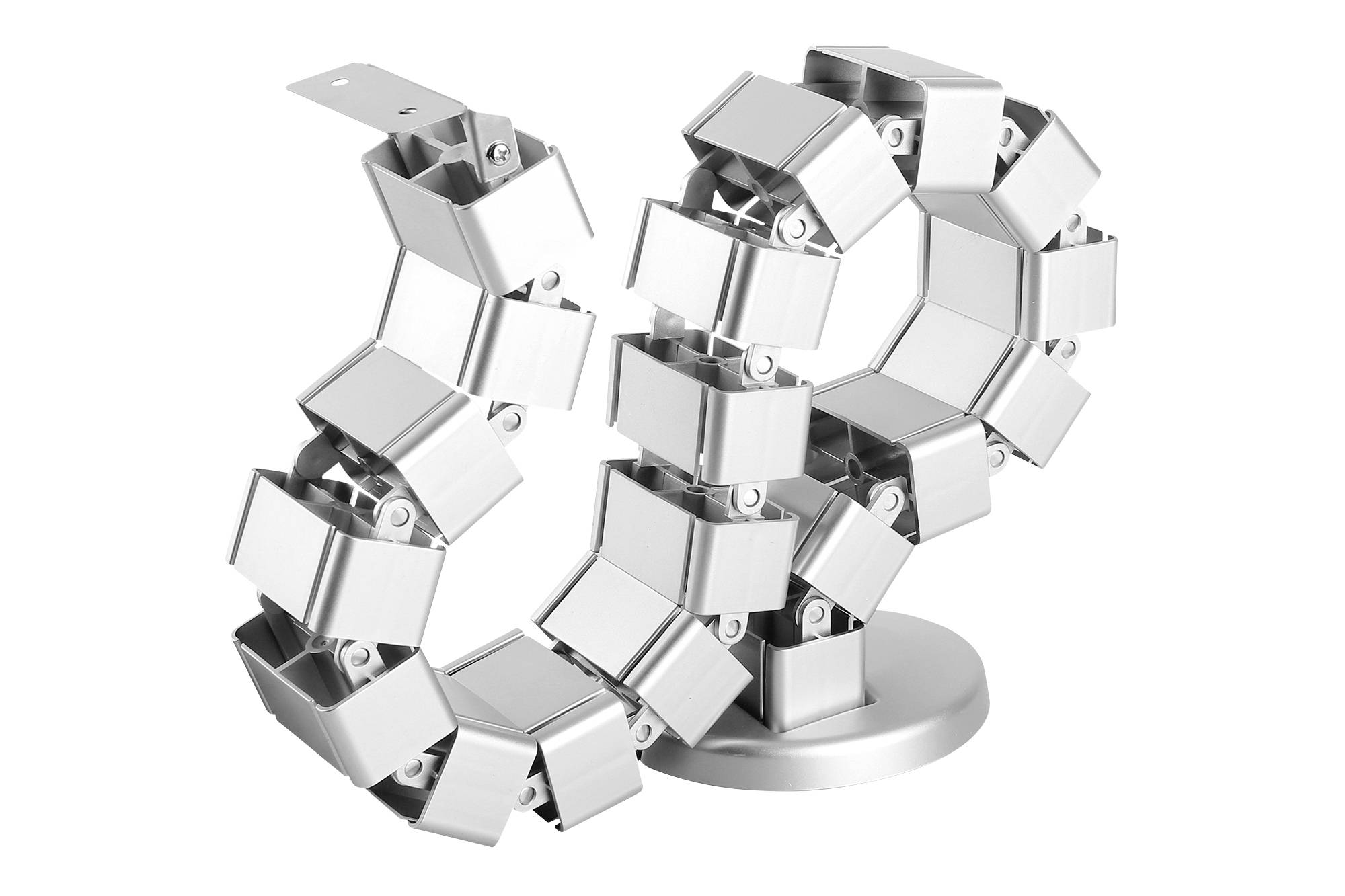 Een zilveren, sculpturale ketting van metalen kubussen, die in een spiraalvormige schikking zijn bevestigd op een ronde sokkel.