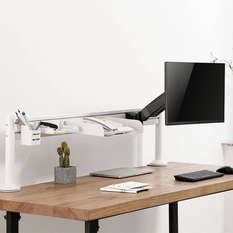 Een stijlvolle houten bureau, uitgerust met een monitor, toetsenbord, cactus, pennen en een notitieboek.