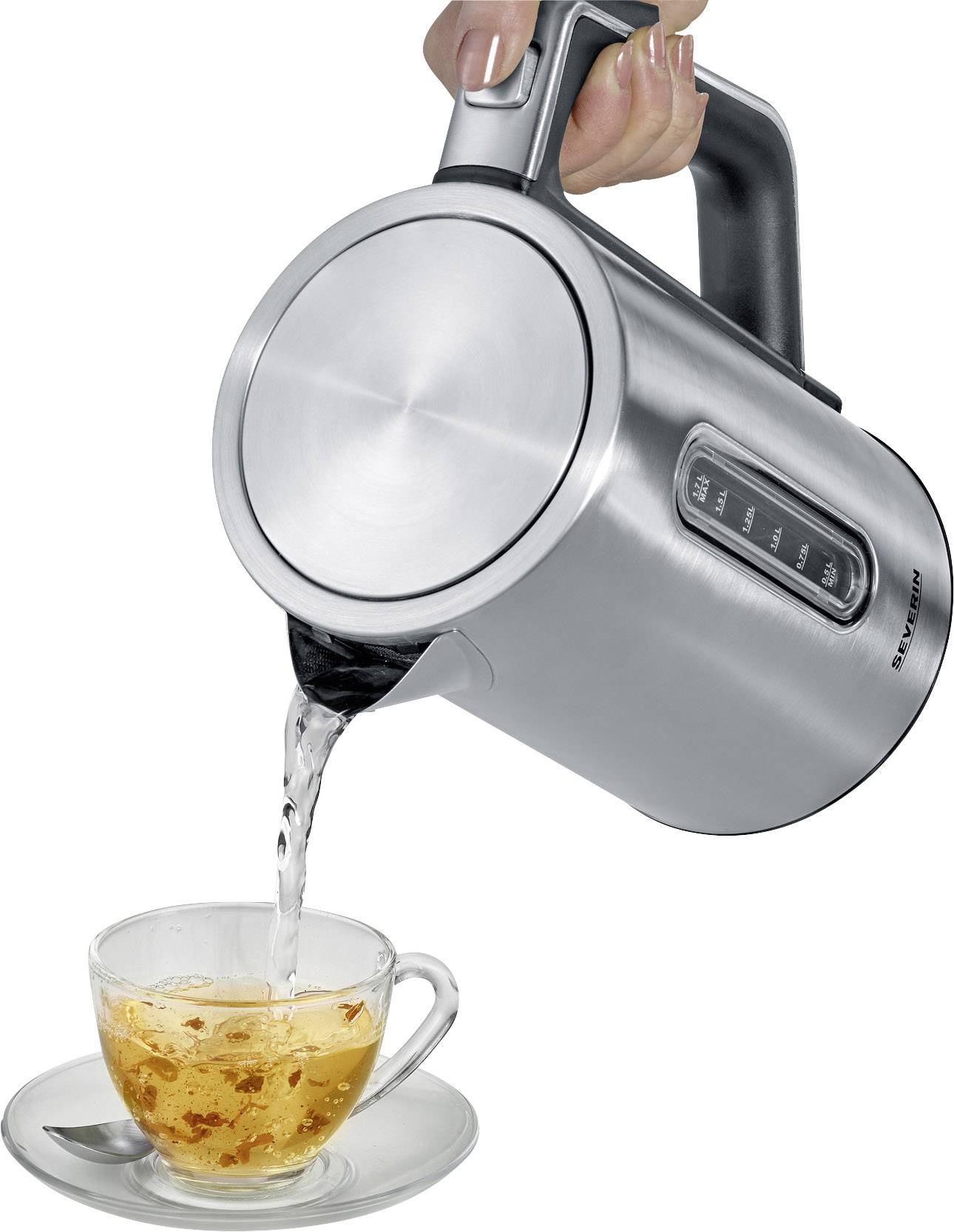 Een hand giet water uit een zilveren waterkoker in een transparante theekop.