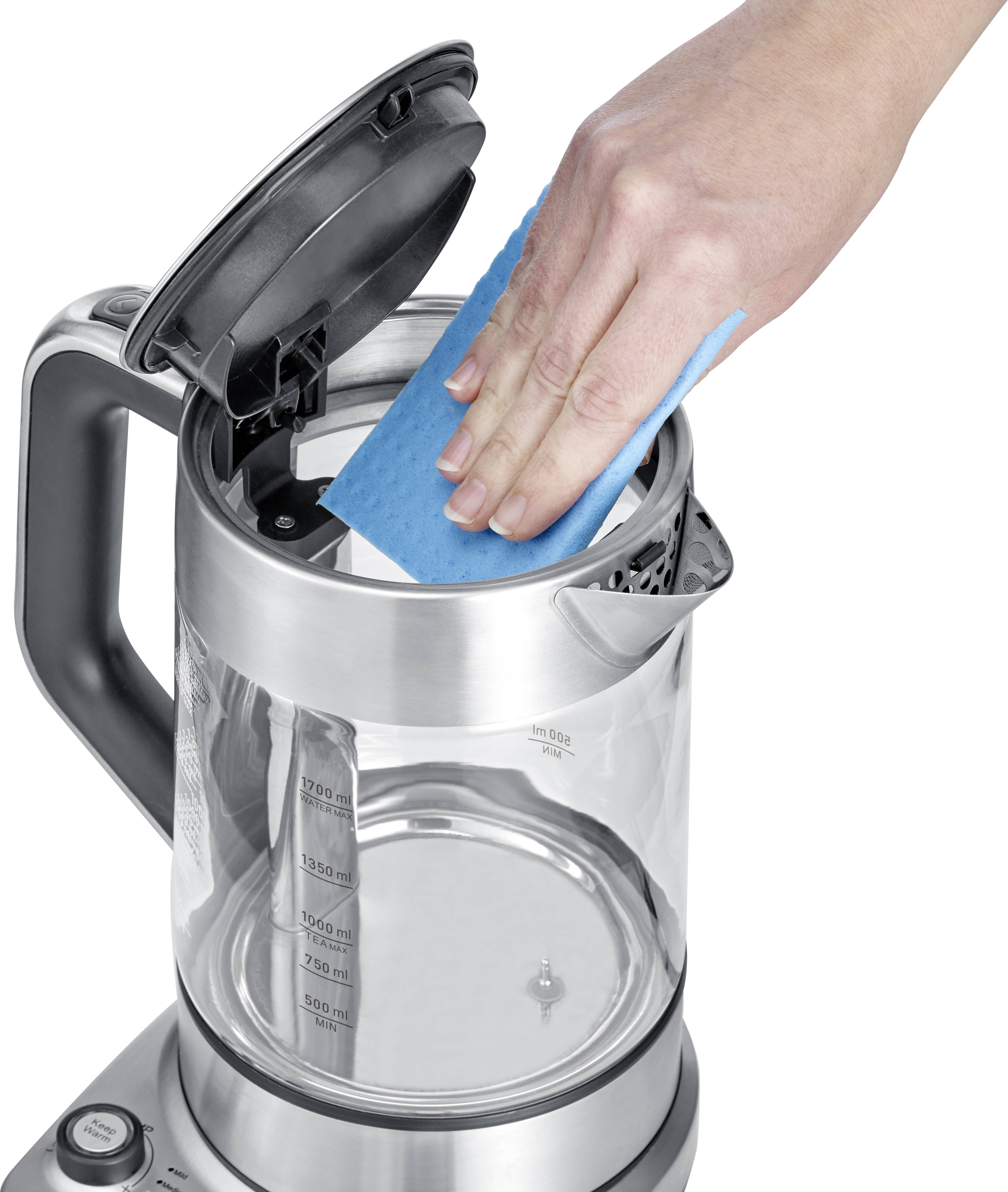 Een hand reinigt de binnenkant van een waterkoker met een blauwe spons. De deksel van de waterkoker staat open.