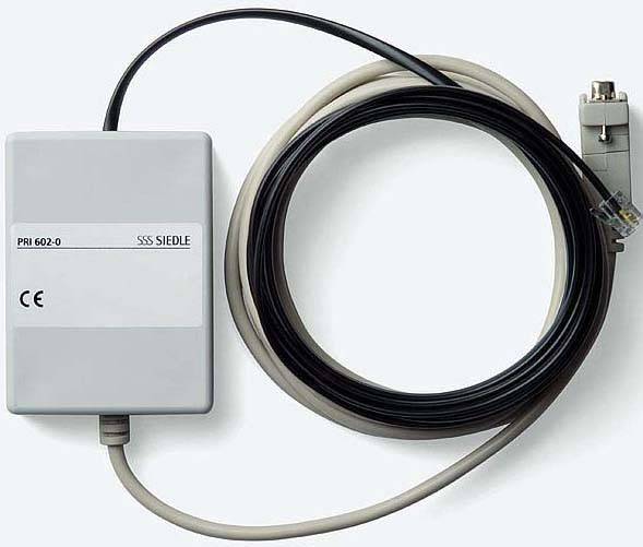 Een grijs Siedle PRI 602-0 apparaat met CE-markering, verbonden met een lange, zwarte kabel en een stekker.
