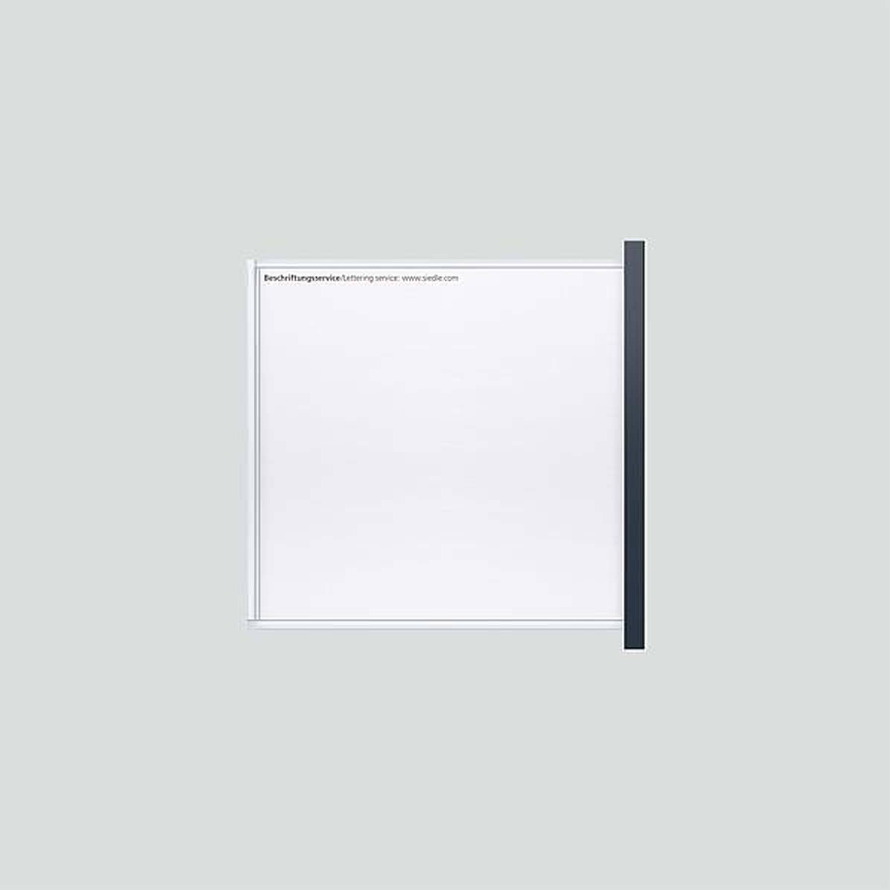 Een leeg wit bord met zwarte rand, schuin tegen een lichtgrijze muur geplaatst, met bovenaan de tekst: 'Opschriftmateriaal: www.omlo.com'.
