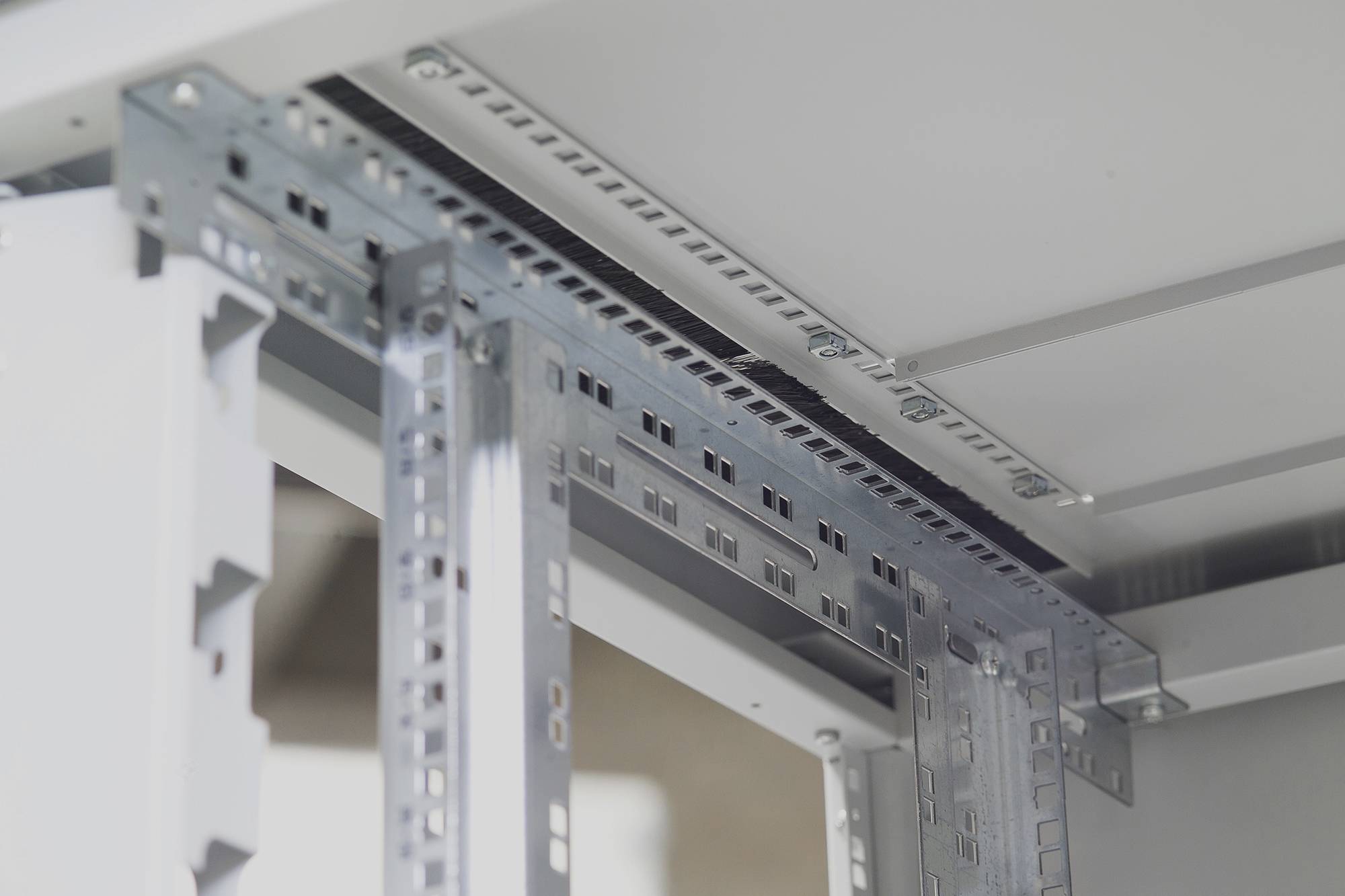 Metalen frames en bevestigingen in een kast of behuizing, mogelijk voor elektronica of serverinstallatie.