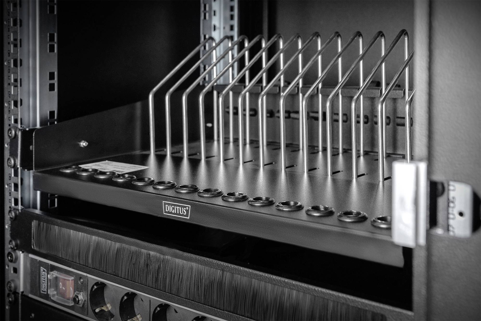 Netwerkkast met een kabelbeheersplank en verticale metalen stangen voor een nette kabelindeling.