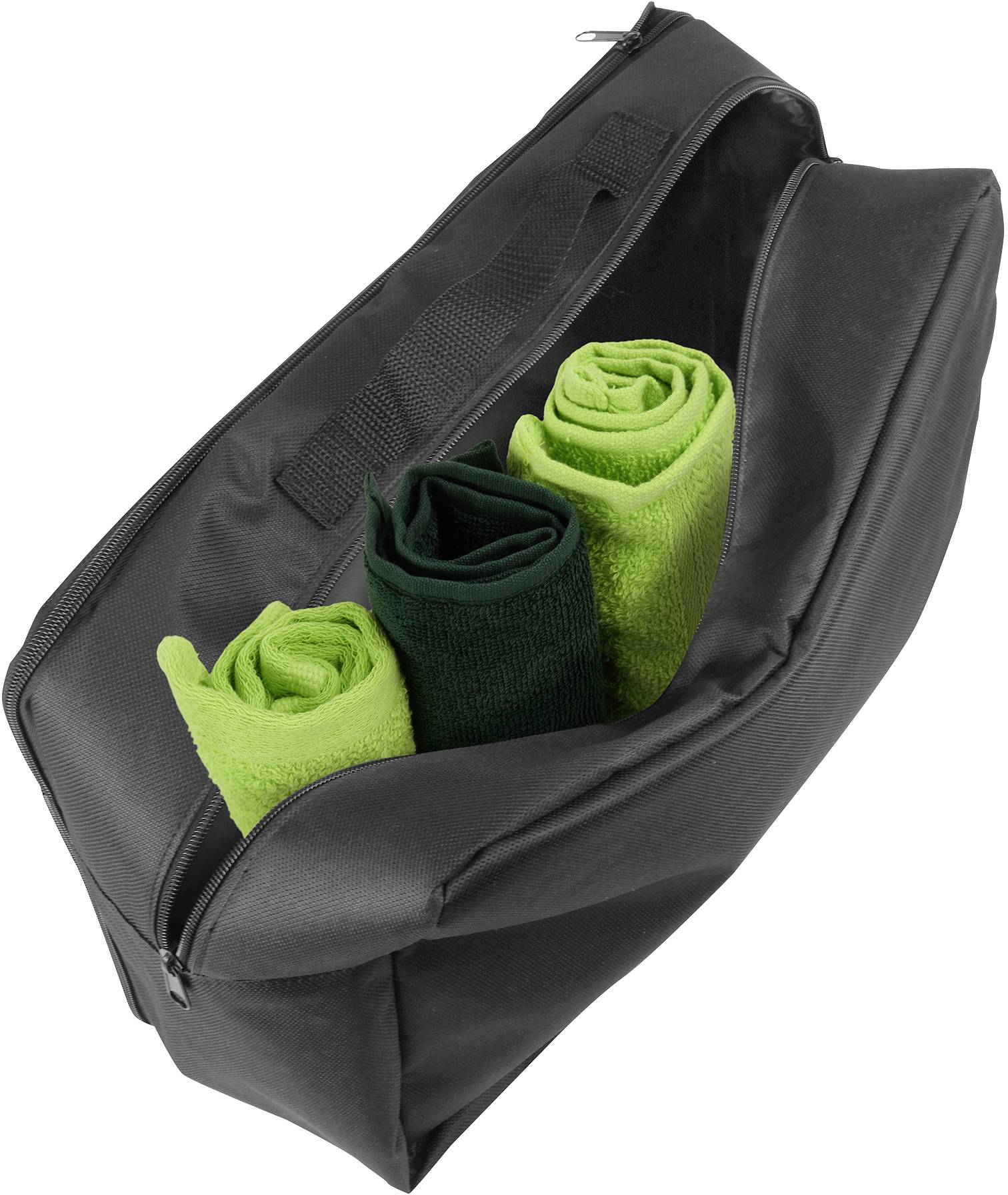 Zwarte tas open met drie opgerolde handdoeken in verschillende groentinten.