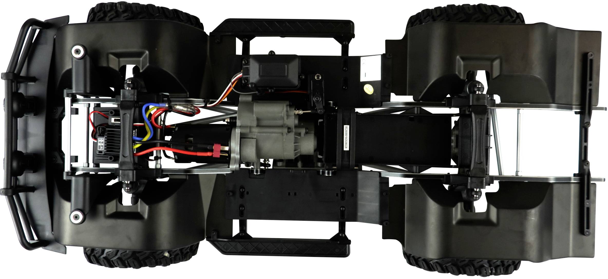 'Onderaanzicht van een bestuurbare auto zonder carrosserie, toont motor, kabels en chassis op zwarte achtergrond.'