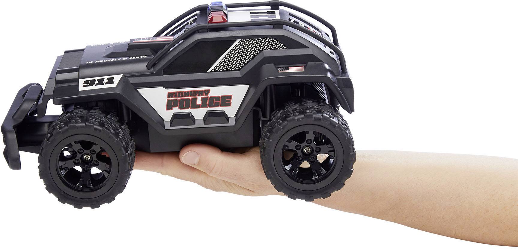 Een hand houdt een klein speelgoed politieauto in offroad-stijl vast met de opschriften 'Security Police' en '911'.