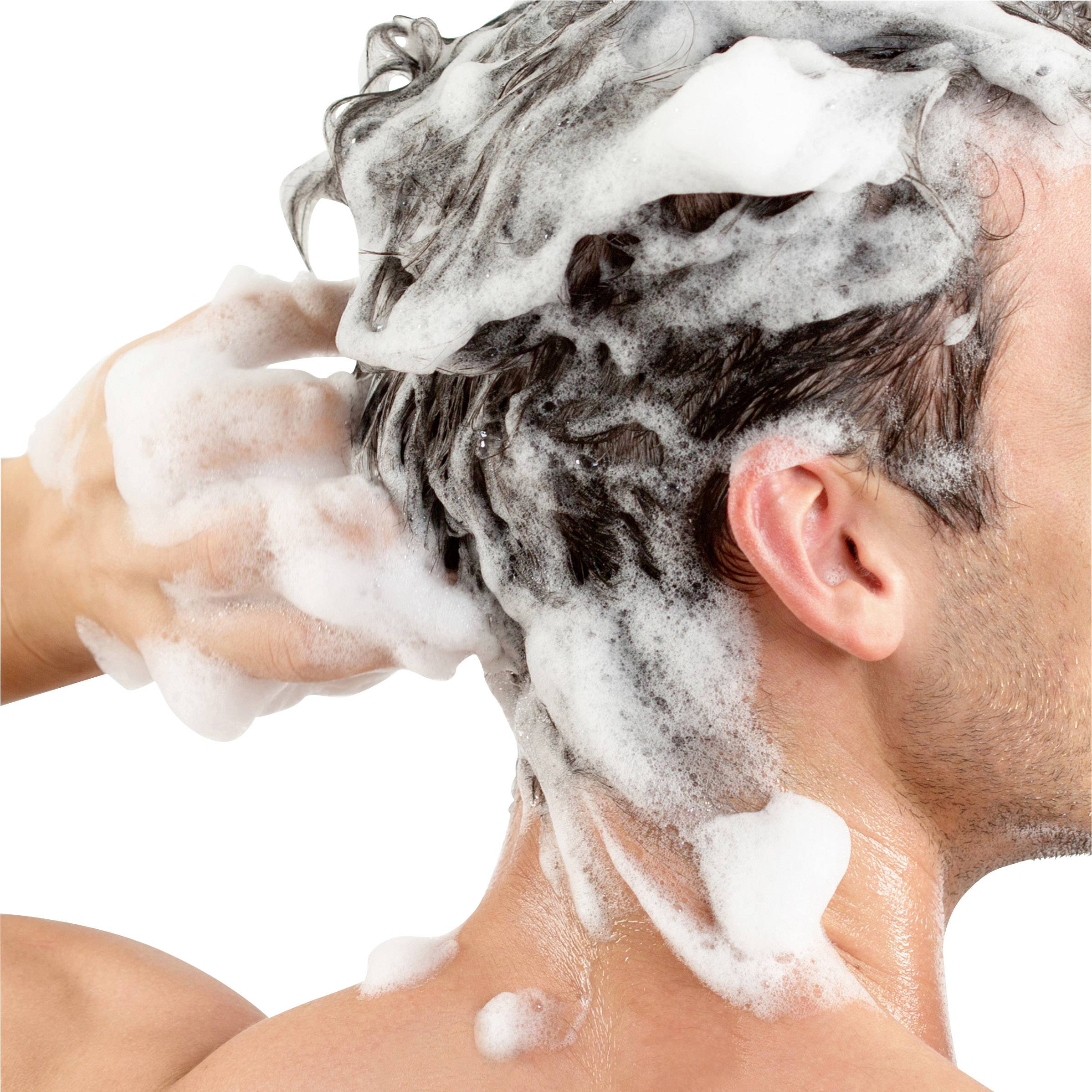 Een man wast zijn haar met schuimend shampoo.