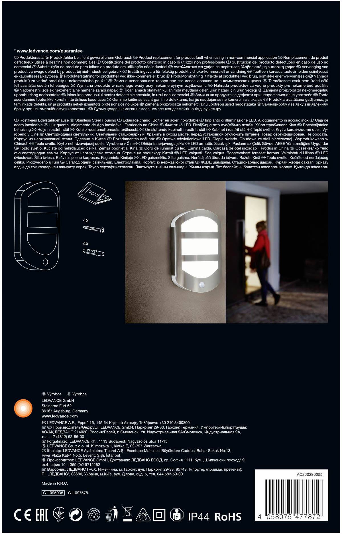 Een verlicht naambordje aan een muur. Op de achtergrond betreedt een persoon een donkere ruimte door een deur.