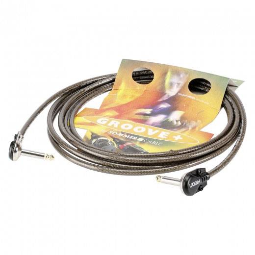 Een spiraalvormig opgerolde gitaarkabel met metalen stekkers, gepresenteerd op een verpakking met het opschrift 'Groove+ Zomer Kabel'.