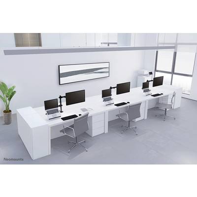 Een modern, minimalistisch kantoor met vier werkplekken. Elke werkplek heeft een scherm, laptop en bureaustoel. Op de achtergrond staat een printer.