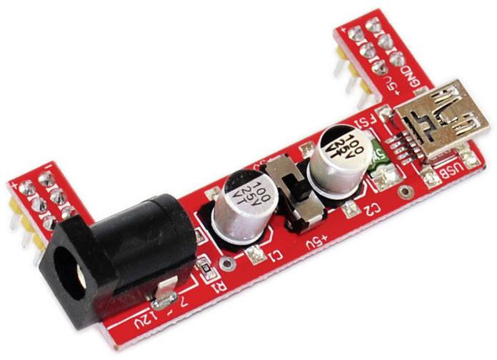 Rode USB-voedingsschakeling met meerdere condensatoren en aansluitingen, bestemd voor spanningsregulatie in elektronische projecten.