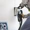 Een persoon werkt met een elektrisch gereedschap aan een muur om een sleuf voor kabels te maken.